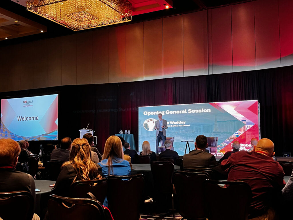 A photo of Alex Waddey, President of NAI Global, at the opening session of the Conference 2026.
